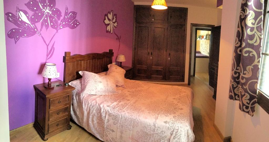 ベナオカスにあるCasa El Cabreroの紫の壁のベッドルーム1室(ベッド1台付)