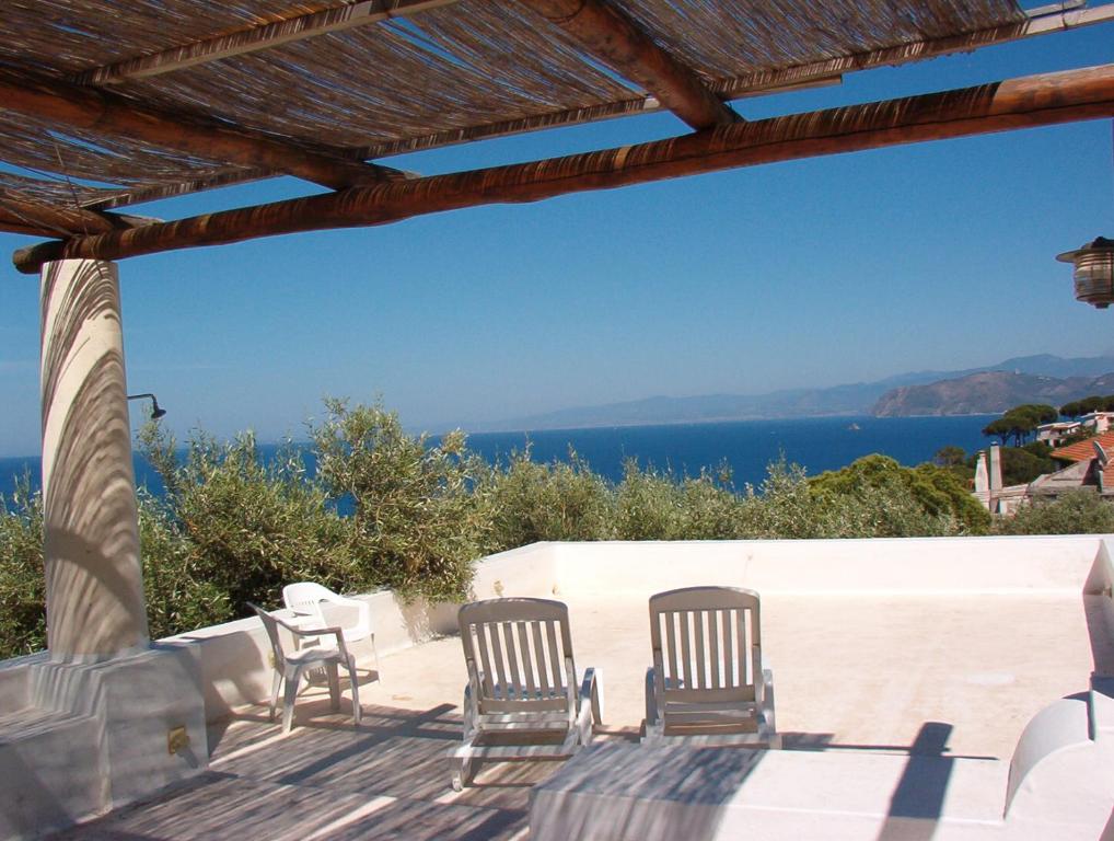 um pátio com cadeiras e vista para o oceano em Villa Eoliana em San Giorgio