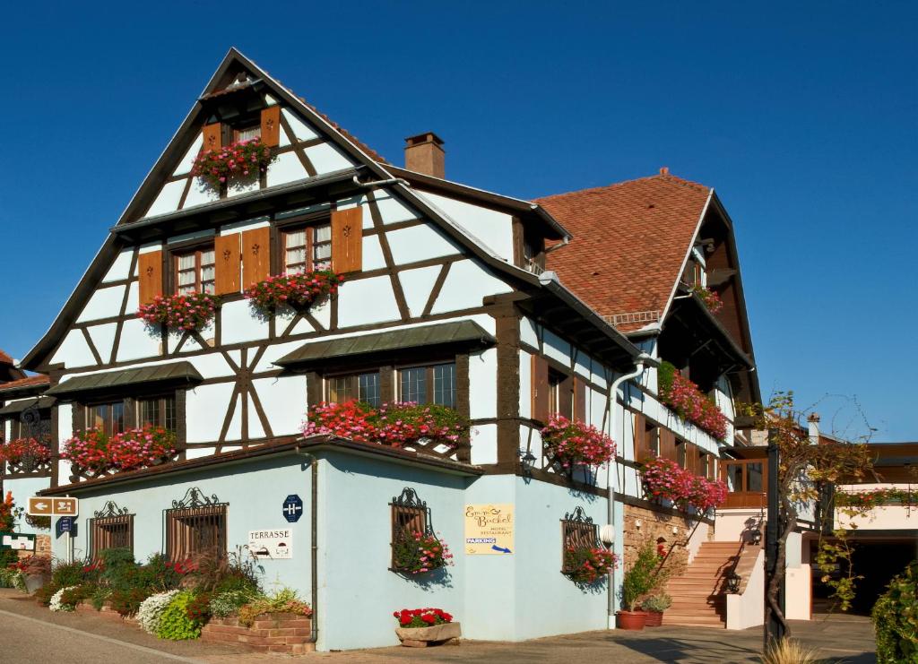 a building with flower boxes on the front of it at Hotel Restaurant Faller Emmebuckel in Itterswiller