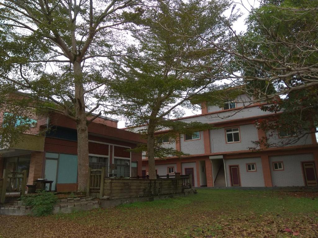 une grande maison avec des arbres devant elle dans l'établissement Dong Li Tea Homestay, à Ruisui