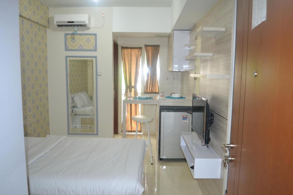 Kleines Zimmer mit einem Bett und einer Küche in der Unterkunft Green Lake View - Tower E 59 Acuan Laundry Time in Pondokcabe Hilir