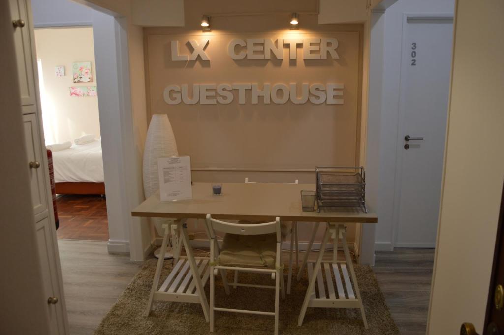 a table and chairs in a room with a sign at Lx Center Guesthouse in Lisbon