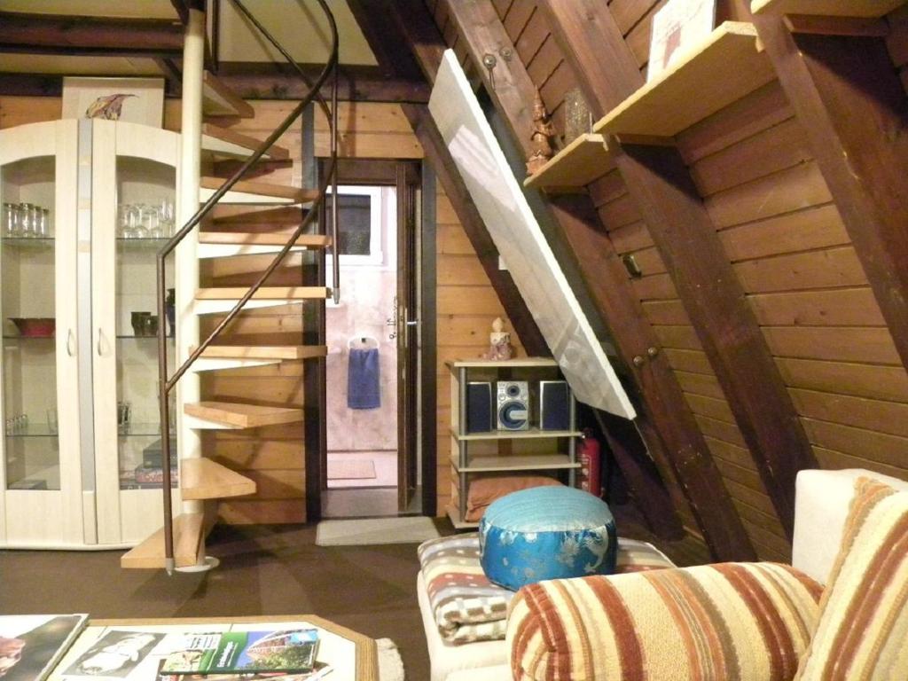 sala de estar con escalera y sofá en Ferienhaus Sommerland Auszeithütte, en Freyung