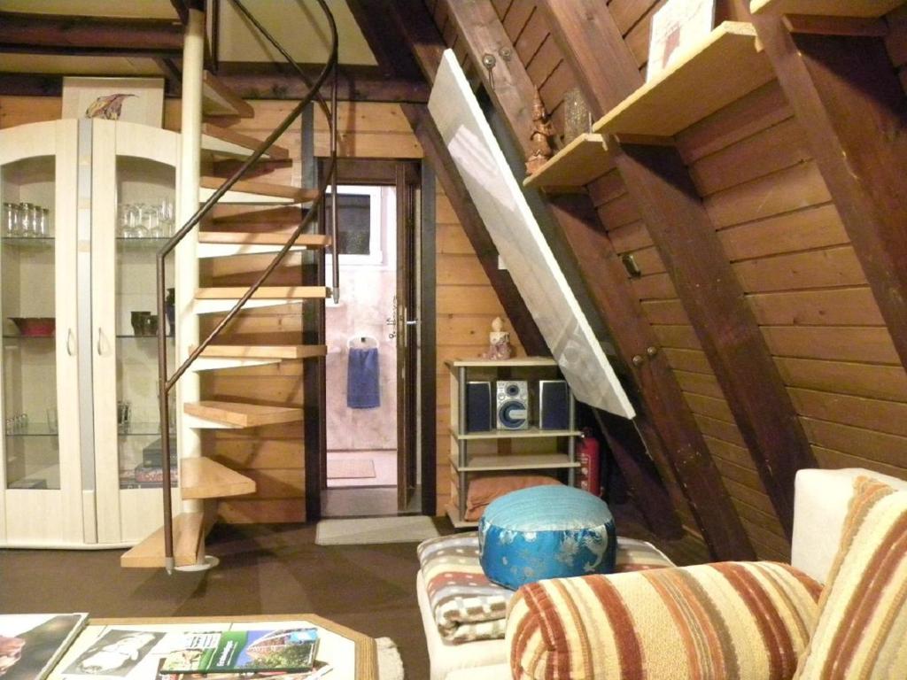 a living room with a staircase and a couch at Ferienhaus Sommerland Auszeithütte in Freyung