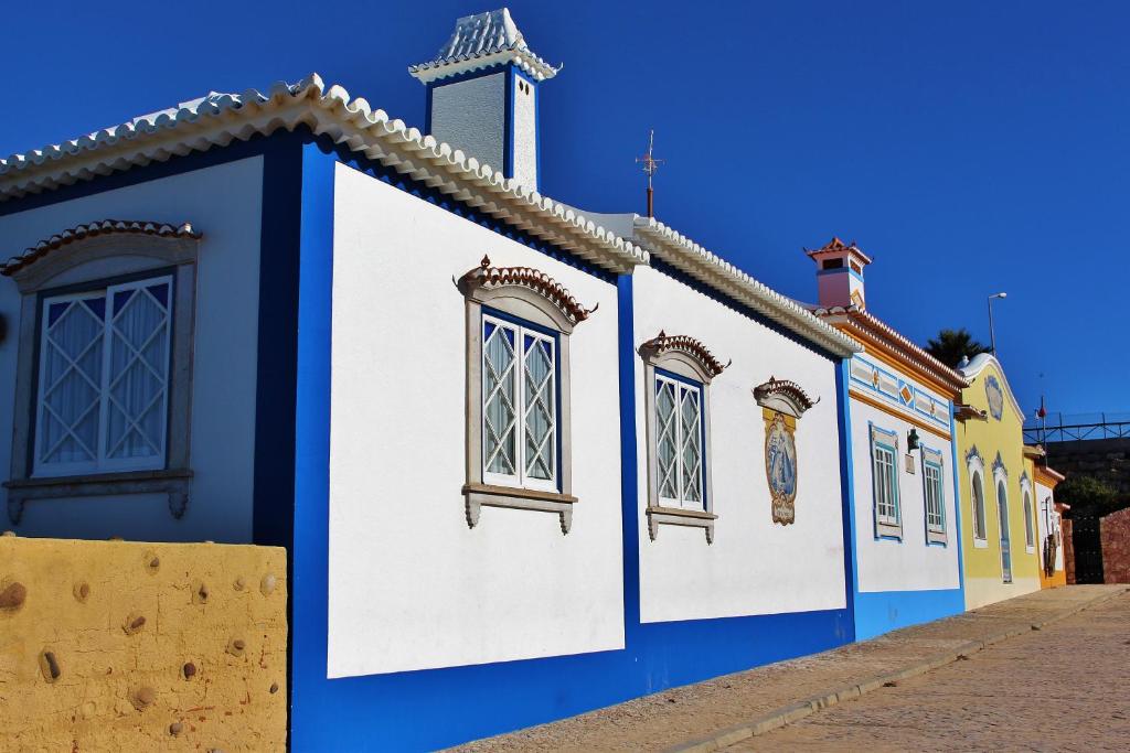 a blue and white building with windows on a street at Villa Ana Margarida Beach in Ericeira