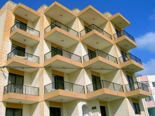 een hoog gebouw met balkons aan de zijkant bij Shamrock Apartments in St Paul's Bay