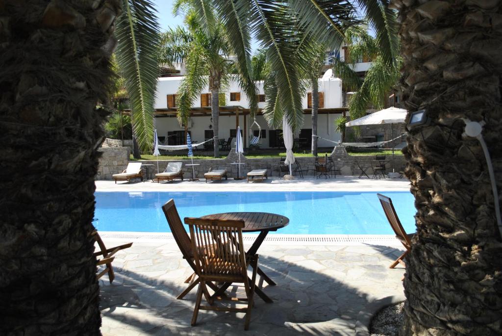 una mesa y sillas junto a una piscina en Paros Eden Park, en Parikia