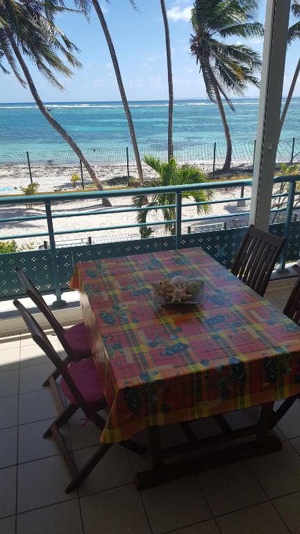 a table and chairs with a view of the beach at les touloulous in Sainte-Anne