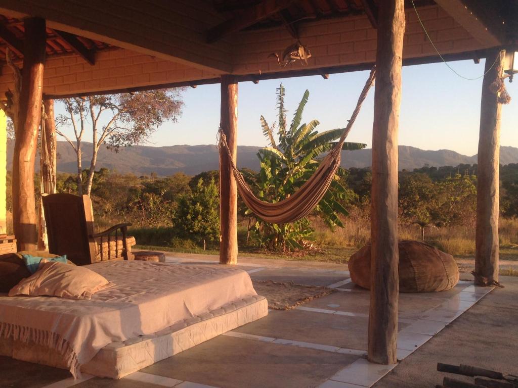 een bed in een veranda met een hangmat en uitzicht bij Chácara Canto da Mata in Cavalcante