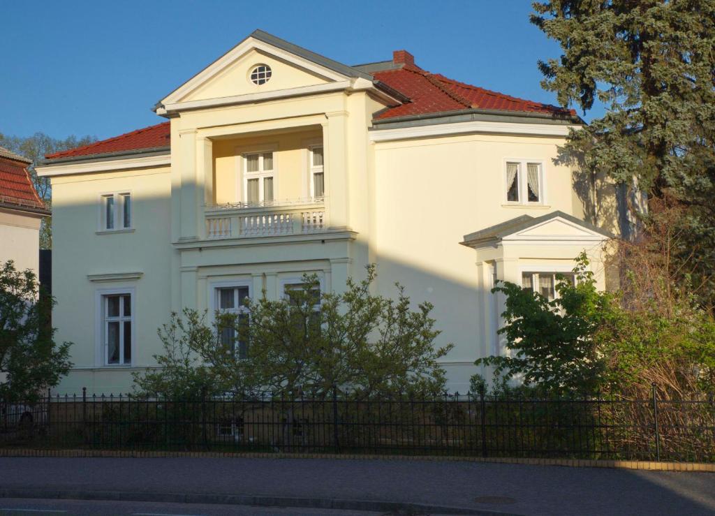 een groot wit huis met een rood dak bij Villa Moeller in Treuenbrietzen