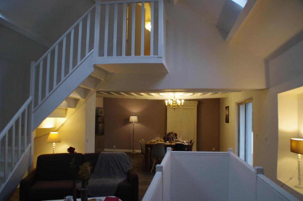 a living room with a staircase and a dining room at La Cour Royale in Bayeux