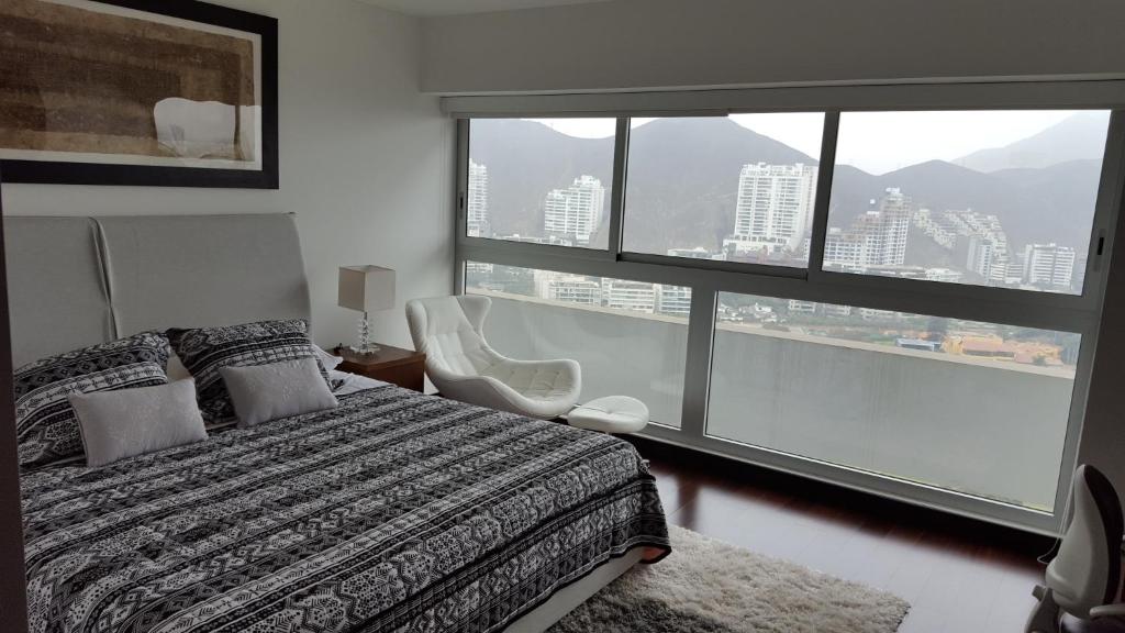 a bedroom with a bed and a large window at Exclusive Apartment in Lima