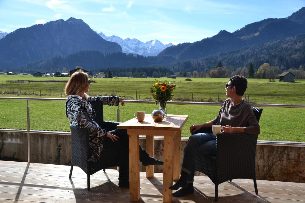 two people sitting at a table on a deck at Louisa in Oberstdorf