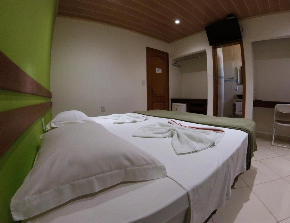 een slaapkamer met een bed met handdoeken erop bij Pousada Belafonte Riocentro in Rio de Janeiro