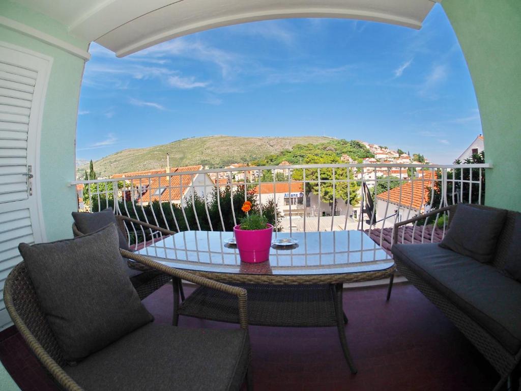 a balcony with a table and chairs and a view at Apartment Sandra in Dubrovnik