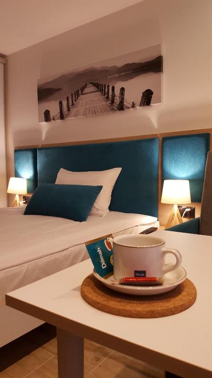 una habitación de hotel con una cama y una taza de café sobre una mesa en Willa Karo en Muszyna