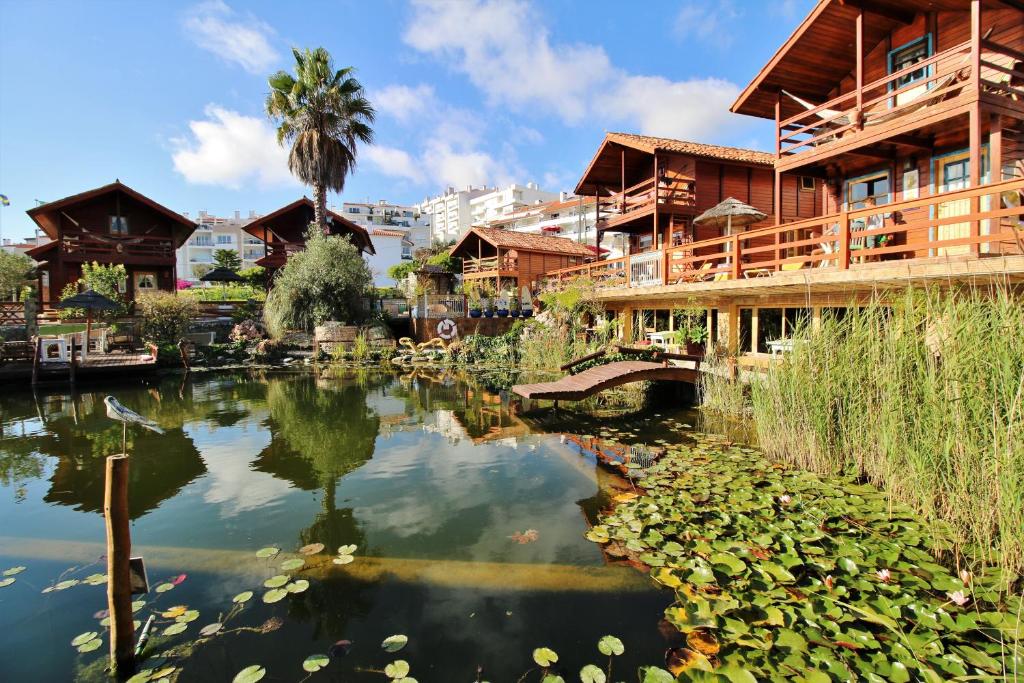 un estanque frente a un complejo con un edificio en Villa Ana Margarida by Nature, en Ericeira
