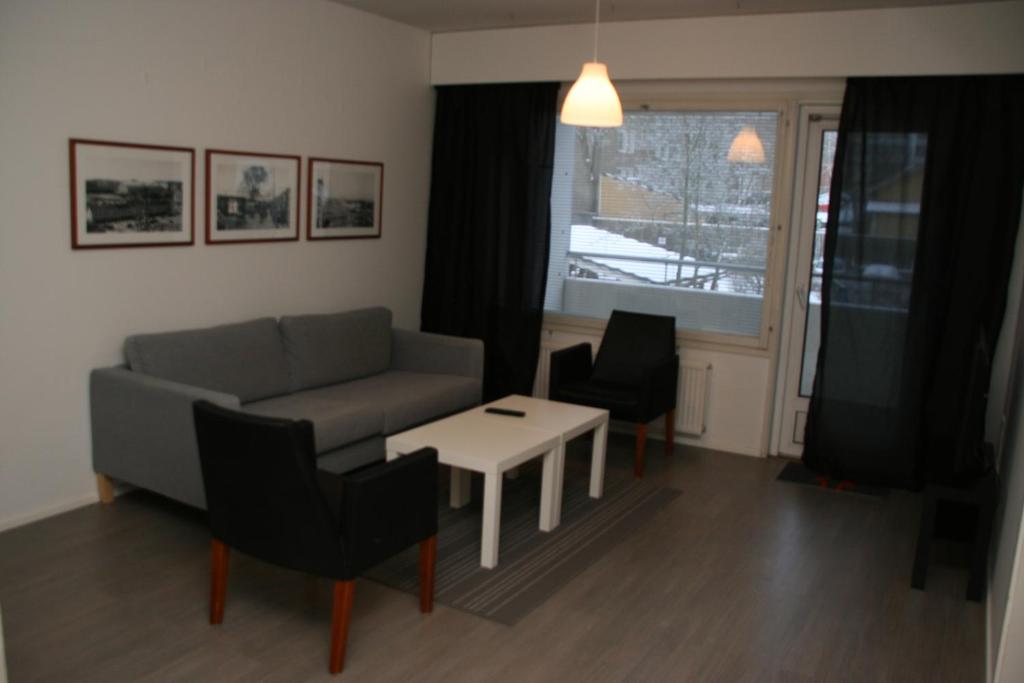 a living room with a couch and a table at City Apartments Turku - 1 Bedroom Apartment with private sauna in Turku
