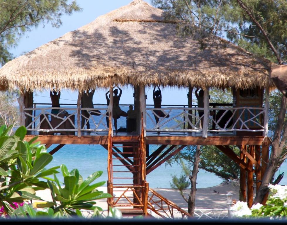 吉利特拉旺安的住宿－日落海灘別墅酒店，海滩上带茅草屋顶的树屋