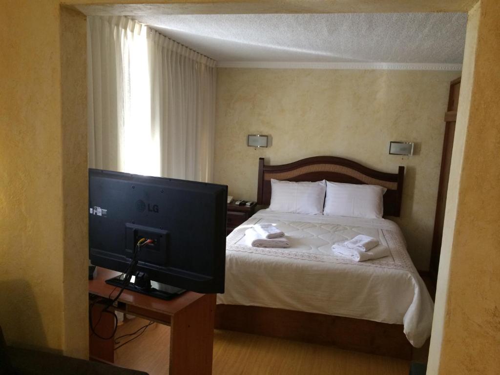 a hotel room with a bed with a television at Hotel San Felipe el Real in San Felipe