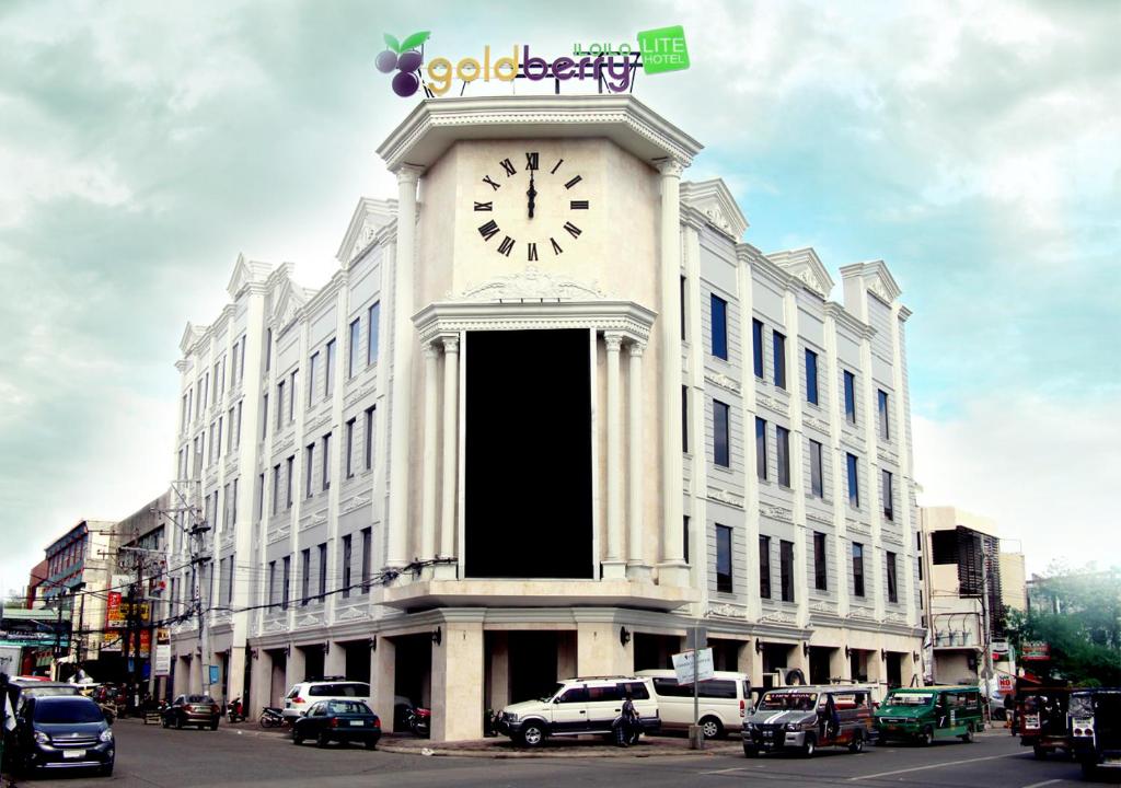 ein großes weißes Gebäude mit einer Uhr drauf in der Unterkunft Goldberry Lite Hotel in Iloilo City