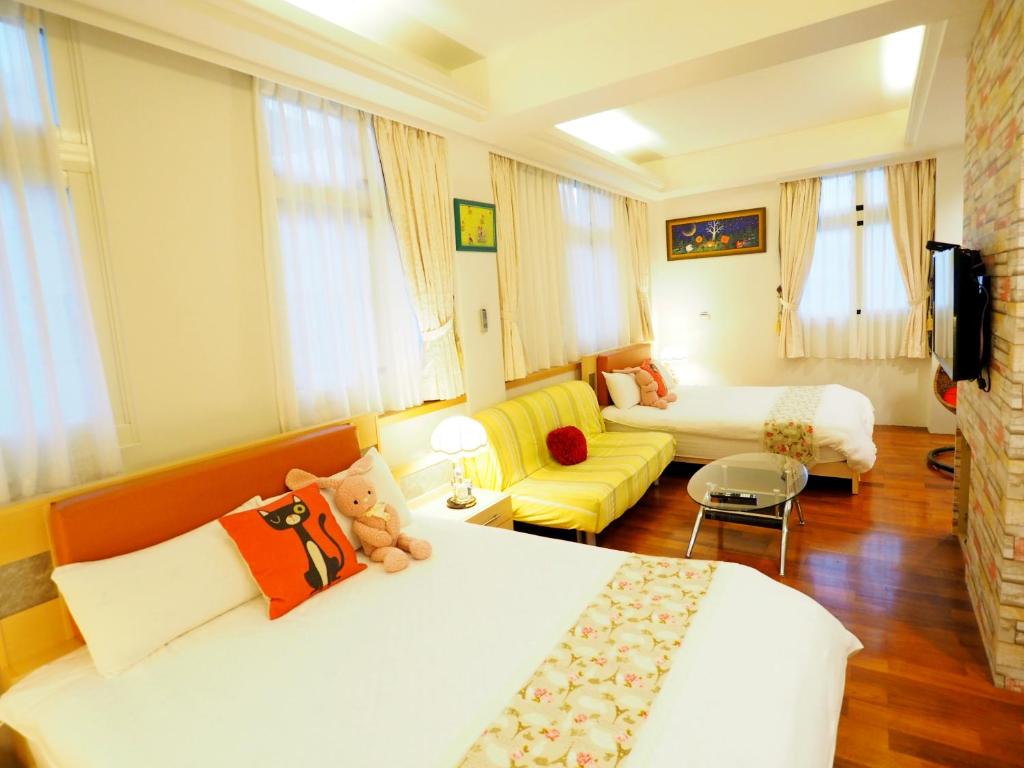 a hotel room with two beds and a couch at Nature House Homestay in Dongshan