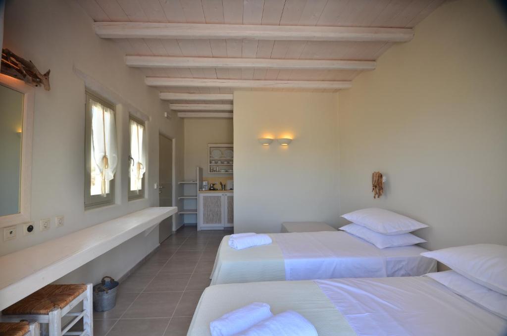 a bedroom with two beds and a tub in it at Portes Houses in Koufonisia