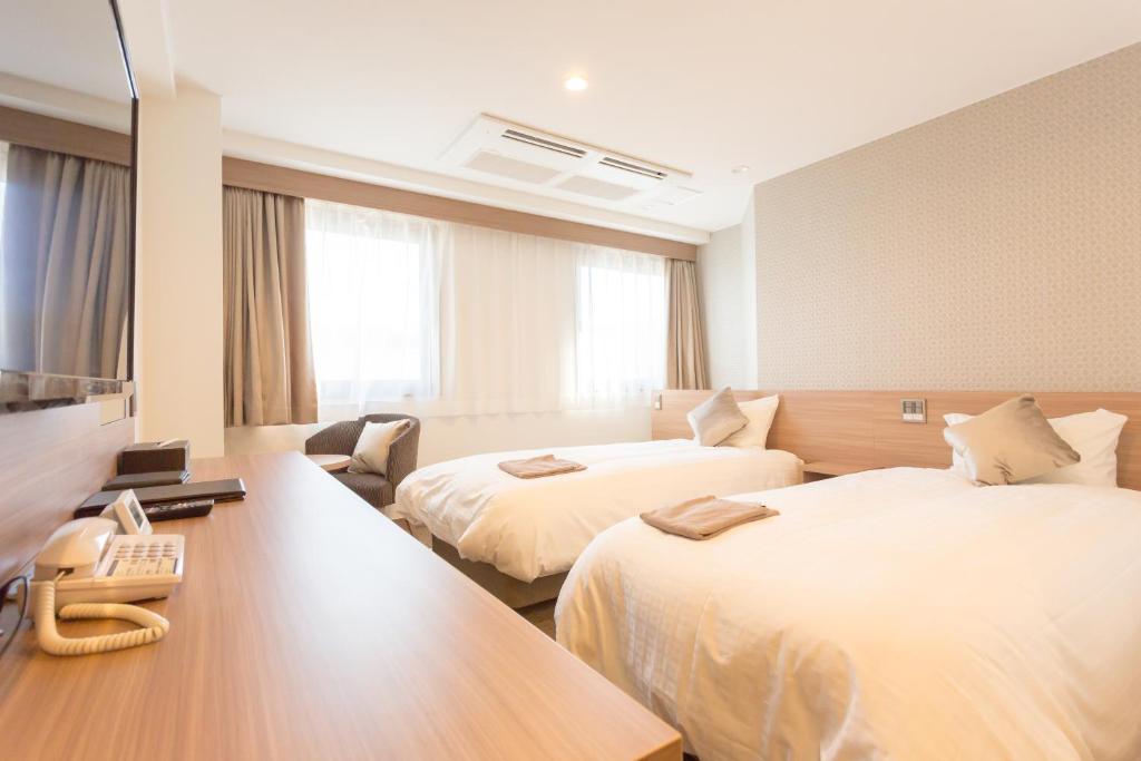 Postel nebo postele na pokoji v ubytování Shimizu City Hotel