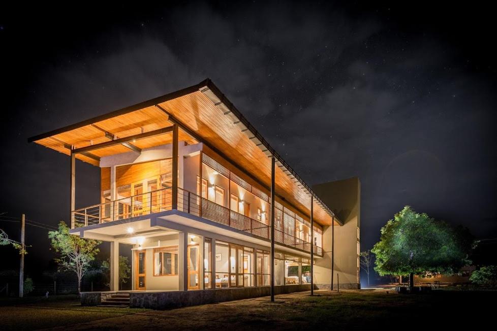 a large building with a balcony at night at Tree Tops Yala in Yala