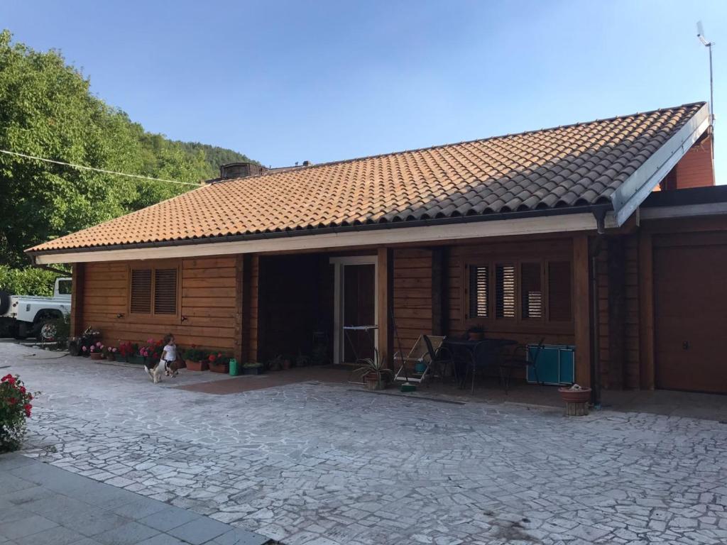 a small wooden house with a dog in front of it at Chalet Paola in Assergi