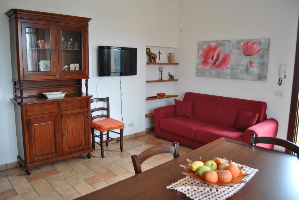 sala de estar con sofá rojo y mesa en Casa Elena en Trapani