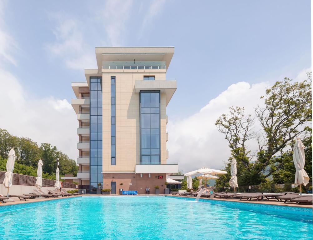 a hotel with a swimming pool in front of a building at Lavicon Hotel Collection in Nebug