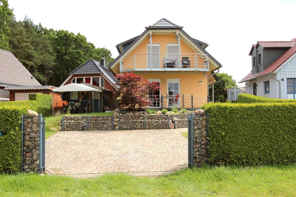 a house with a stone fence in front of a driveway at Haus STRANDLAeUFER _ EG_Fewo in Göhren-Lebbin