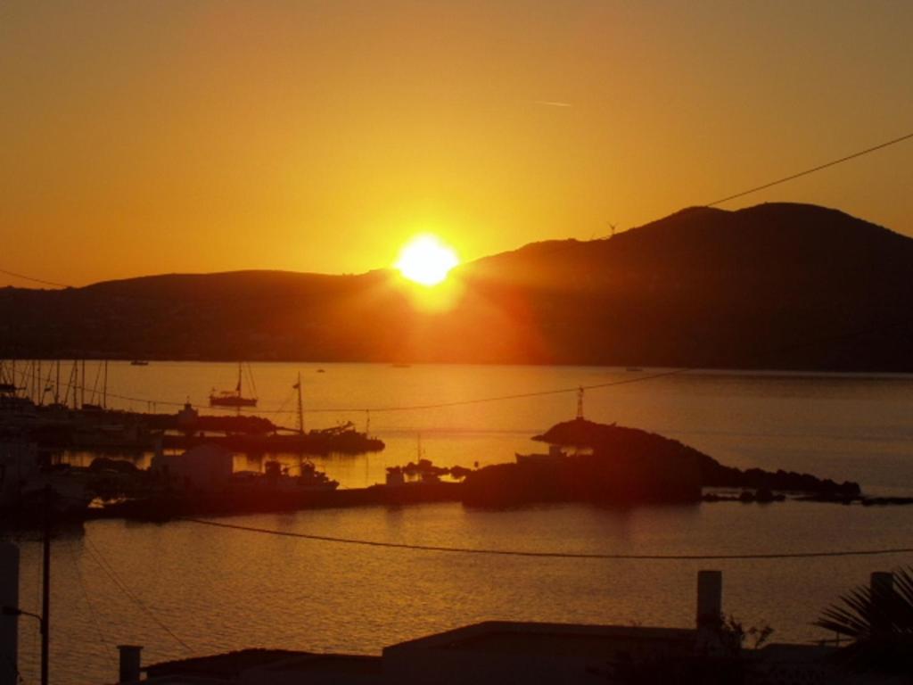 um pôr do sol sobre um porto com barcos na água em Despina's Mare em Naousa