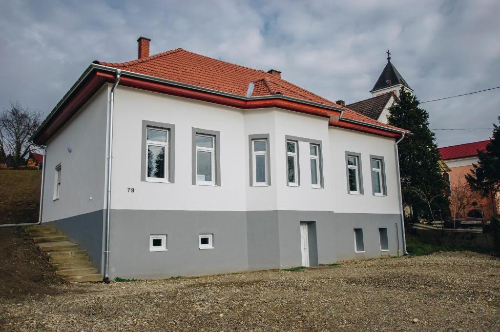 a white house with a red roof at Mosolyka Vendégház in Zákány