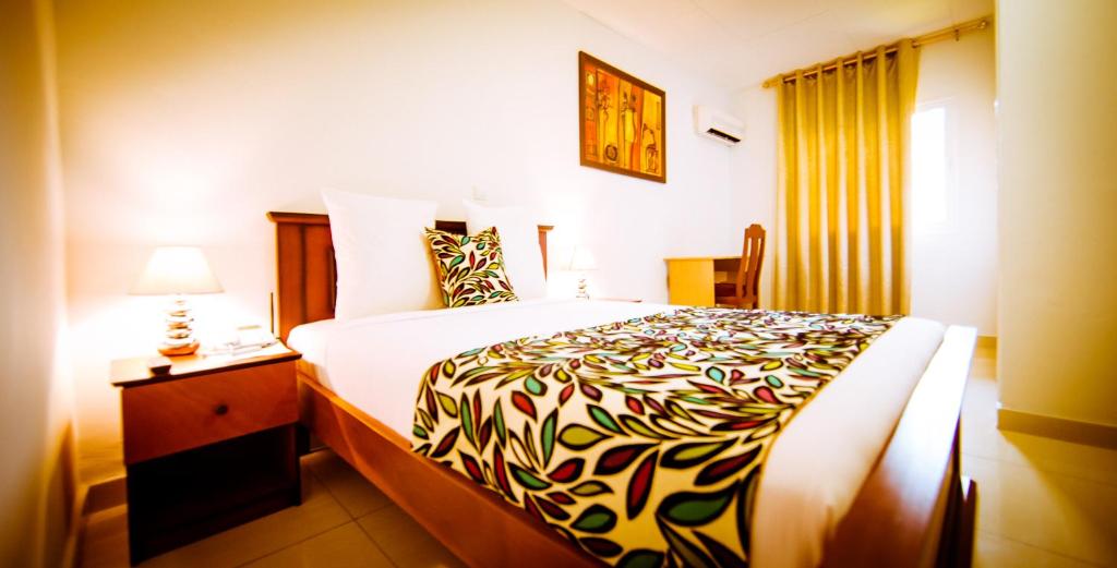 um quarto de hotel com uma cama grande e um candeeiro em Hotel Adagio em Libreville