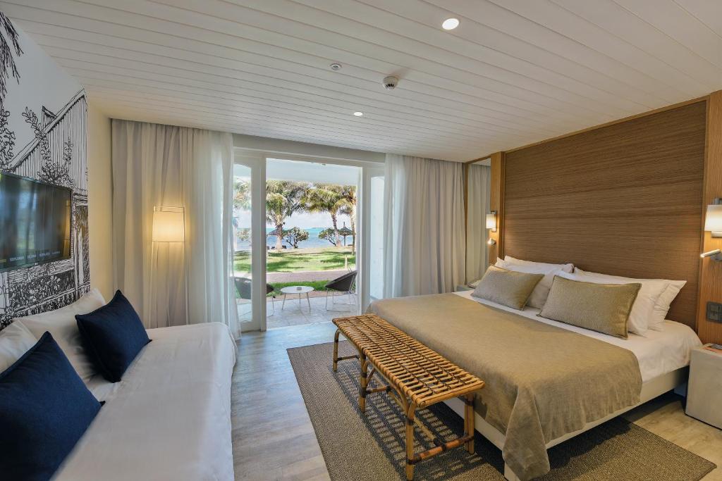 A bed or beds in a room at Canonnier Beachcomber Golf Resort & Spa
