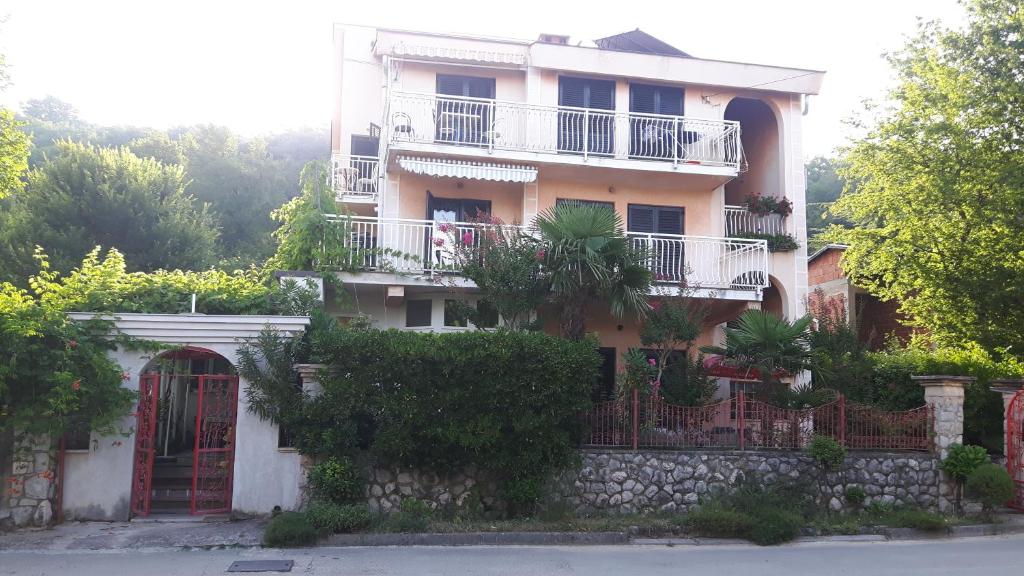 an apartment building with a balcony and a fence at Villa Maja in Omišalj