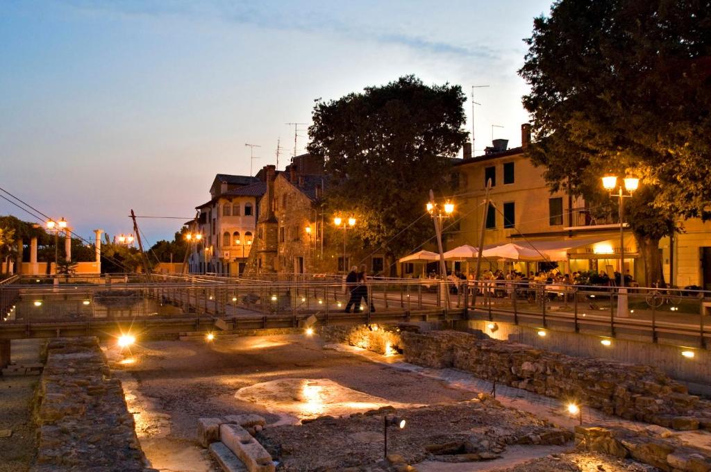 a person walking down a street at night with lights at Appartamento Saturnia in Grado