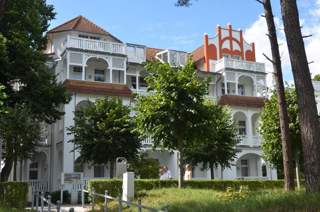 a large white building with trees in front of it at Villa Strandidyll Wohnung 7 in Binz