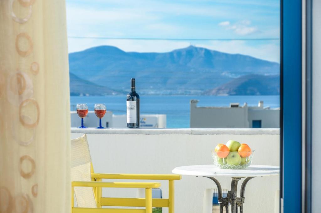a table with a bowl of fruit and wine glasses at Magic Summer in Agia Anna Naxos