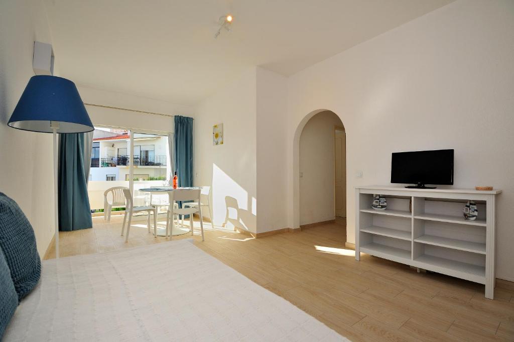 un soggiorno con TV e tavolo con sala da pranzo di Sunhouse a Luz