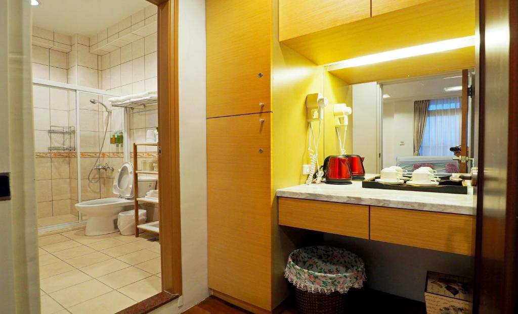 a bathroom with a sink and a toilet and a mirror at Nature House Homestay in Dongshan