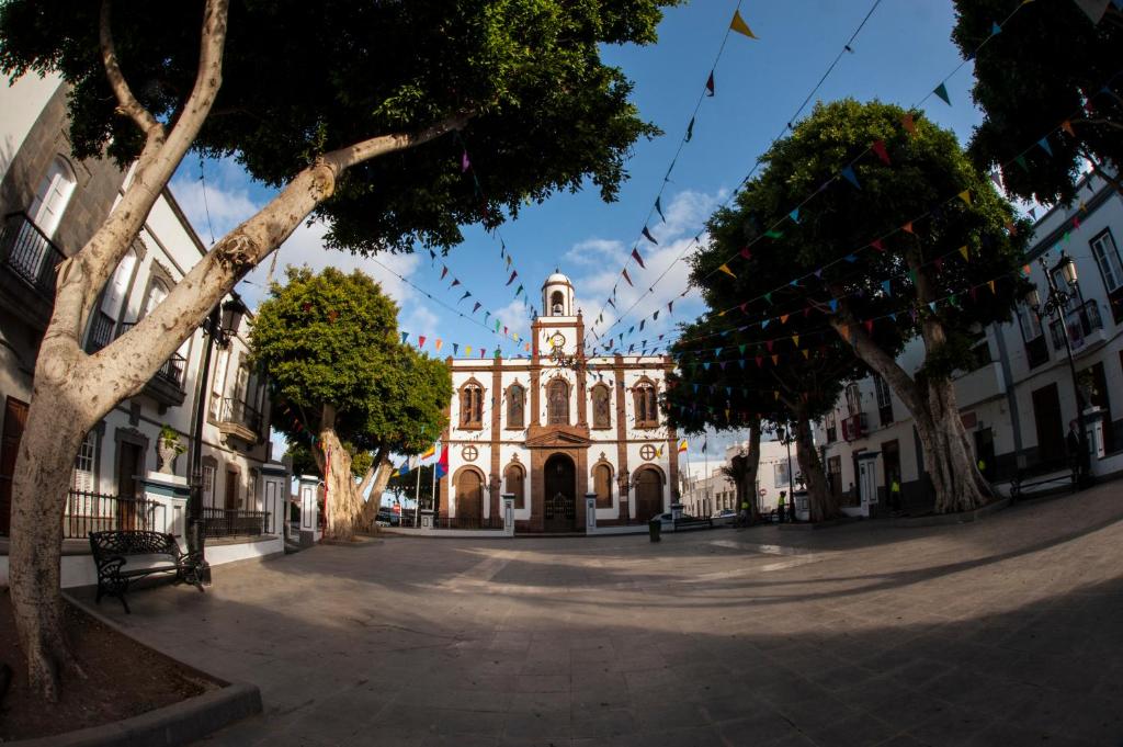 a building with a clock tower in the middle of a street at Casa Lola in Agaete