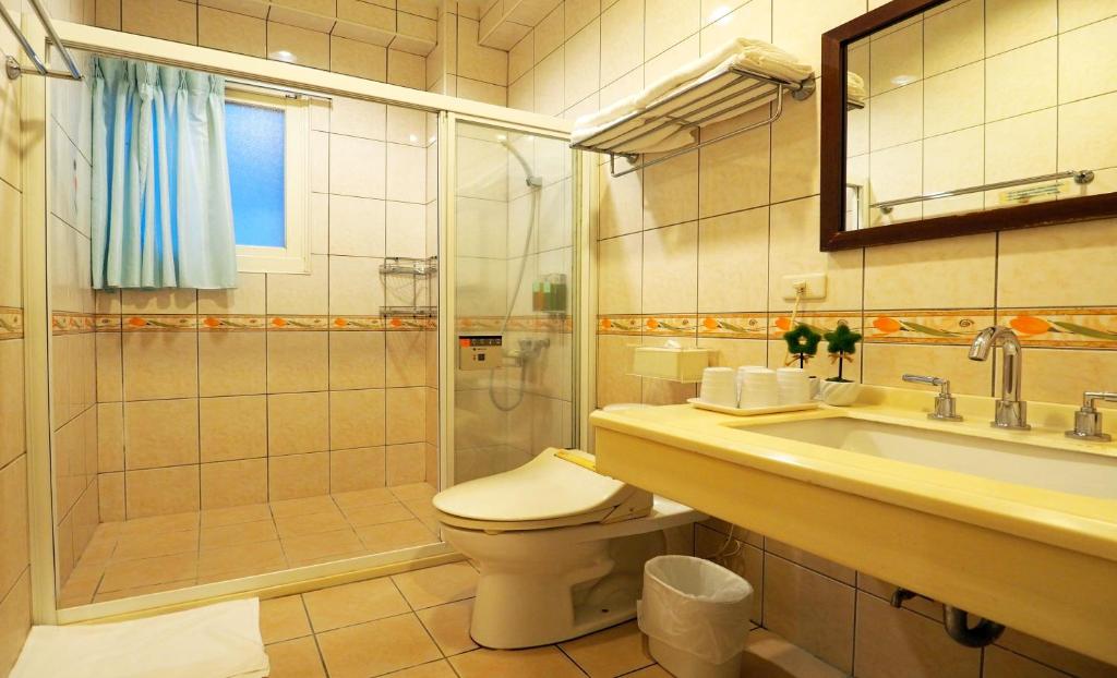 a bathroom with a toilet and a shower and a sink at Nature House Homestay in Dongshan
