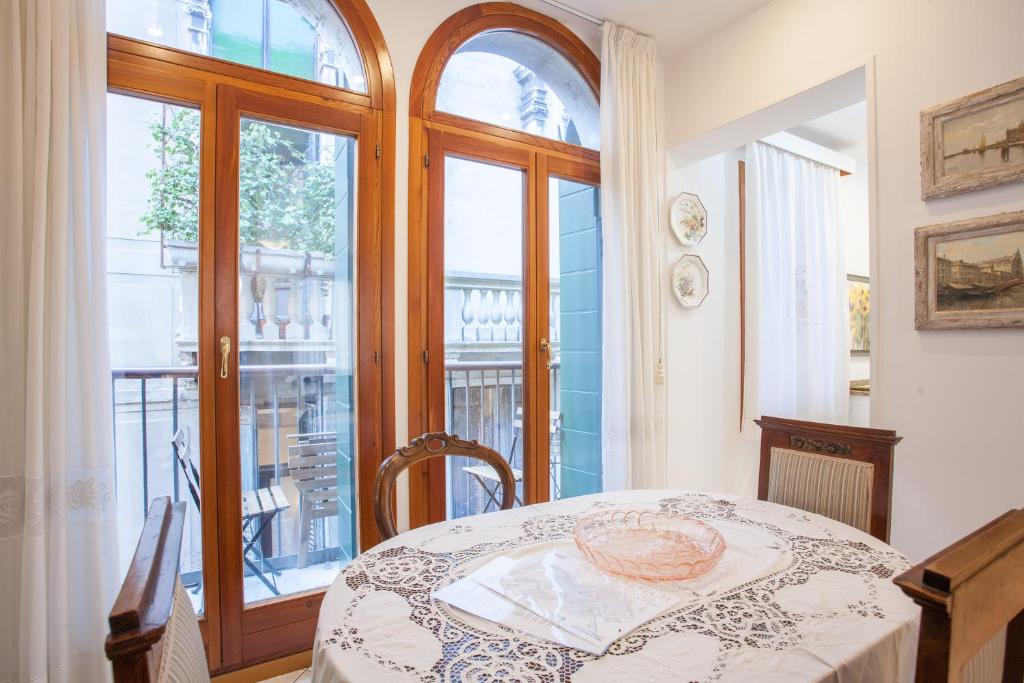 een eetkamer met een tafel en een raam bij San Marco Romantic Dream in Venetië