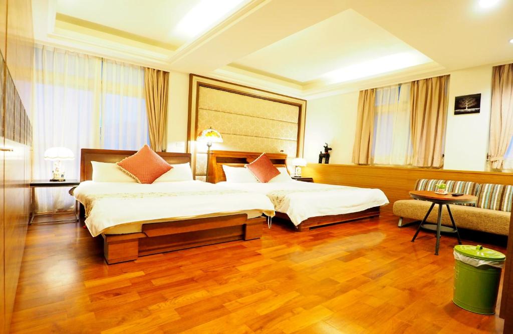 a hotel room with two beds and a couch at Nature House Homestay in Dongshan