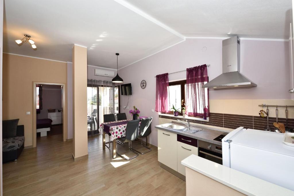a kitchen and living room with a table and chairs at Apartments Lavanda - free parking and grill in Jezera