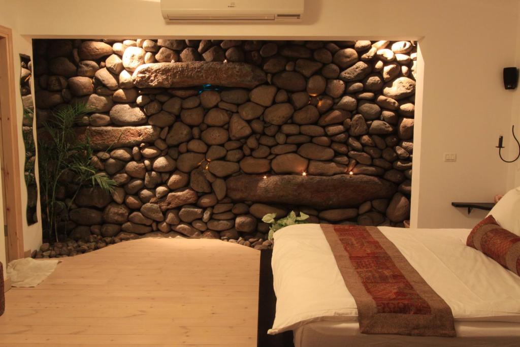 a stone wall in a bedroom with a bed at Volcanes in Had Nes