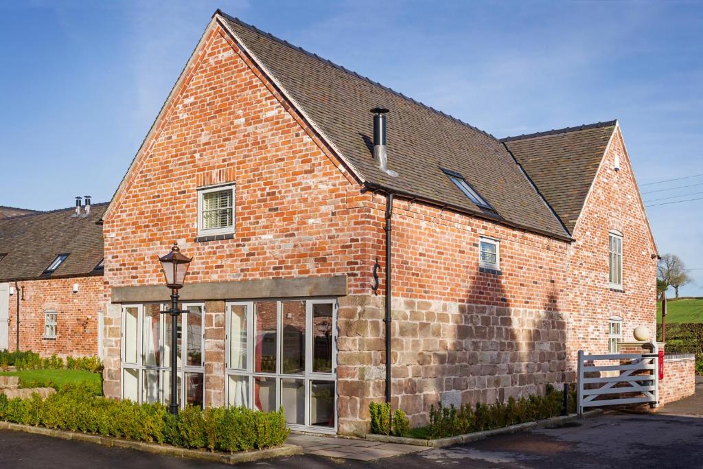 un edificio de ladrillo rojo con techo negro en 1 Collared Dove Barn en Stoke on Trent